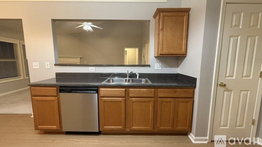 A kitchen with wooden cabinets and a black countertop.