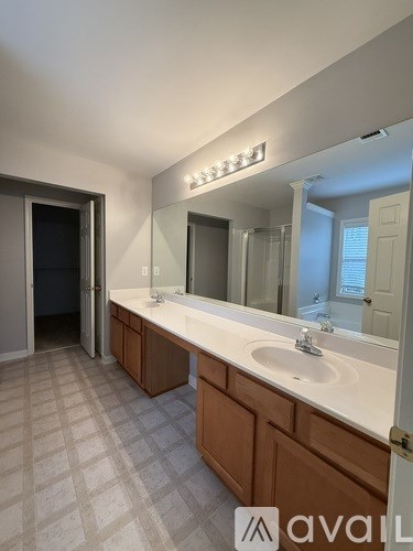 A bathroom with two sinks and a large mirror.