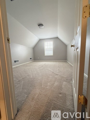 A carpeted room with a door on the right.