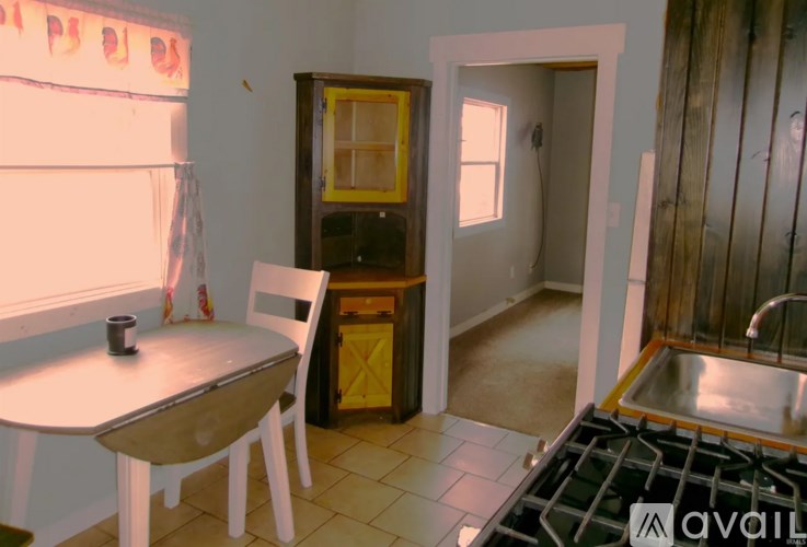 A kitchen with a table and chairs.