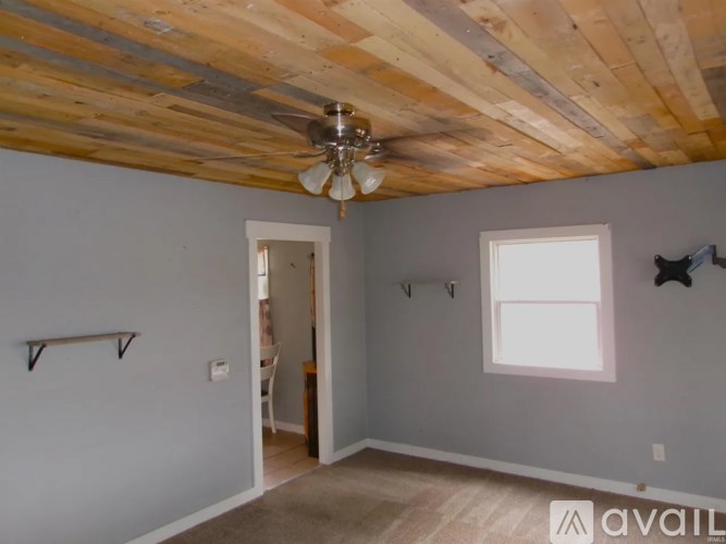 A room with a wooden ceiling and a fan.