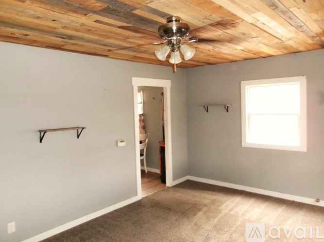 A room with a wooden ceiling and a window.