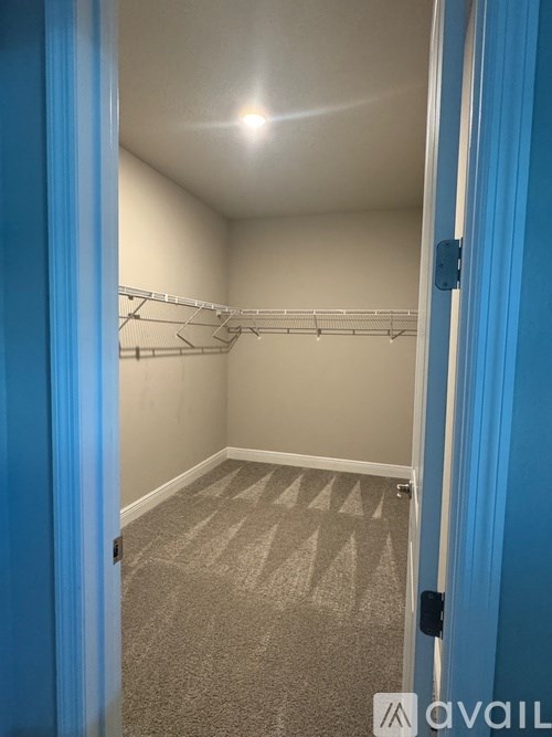 A room with a carpeted floor and a white door.