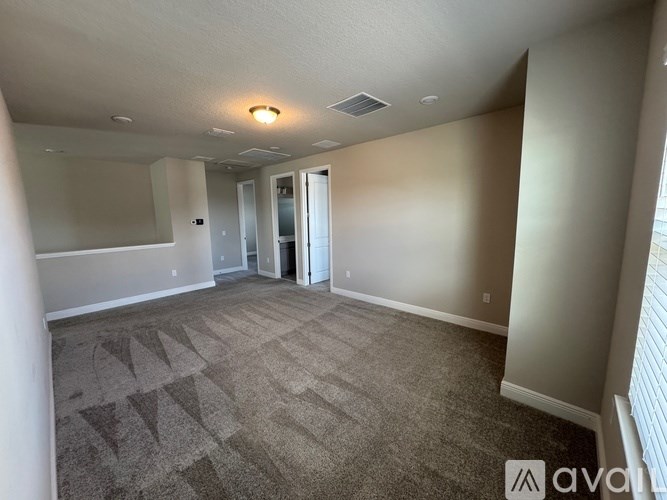 A room with a carpeted floor and a doorway leading to another room.