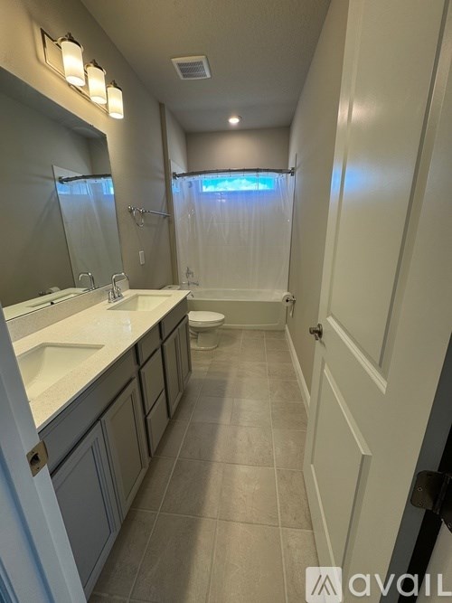 A bathroom with a toilet, sink, and mirror.