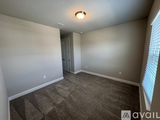A room with a carpeted floor and a door leading to another room.