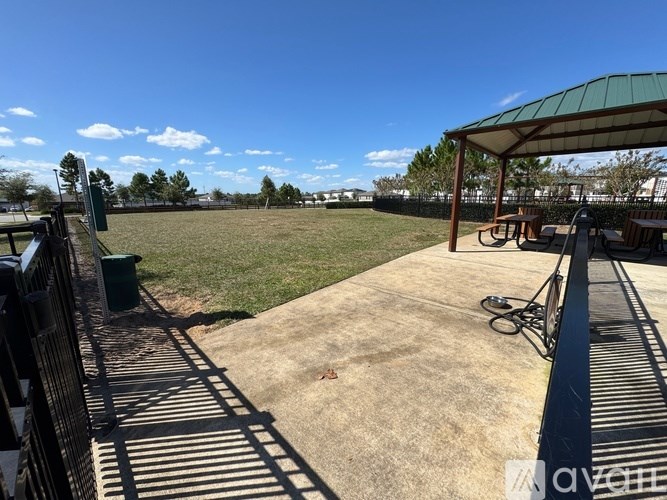 A sunny day at the park with a green canopy and a bicycle leaning against it.