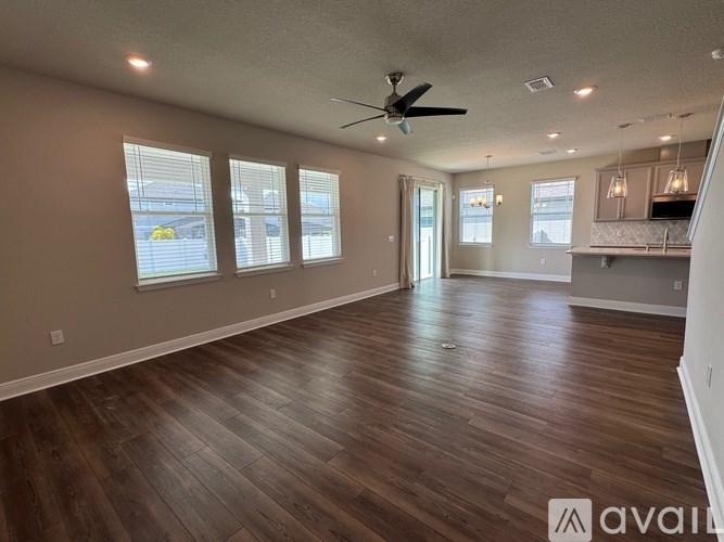 A spacious room with wooden flooring and a ceiling fan.