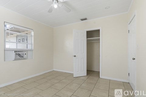 A room with a ceiling fan and a window with blinds.