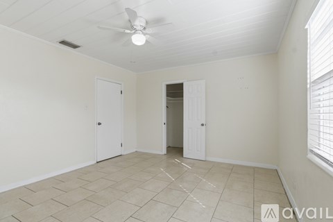 A room with a ceiling fan and tiled flooring.