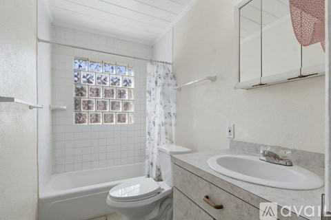 A bathroom with a toilet, sink, and bathtub.