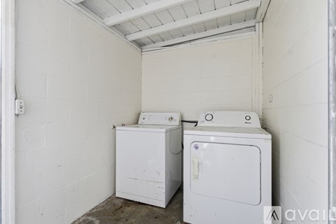 A white washing machine and dryer in a small room.