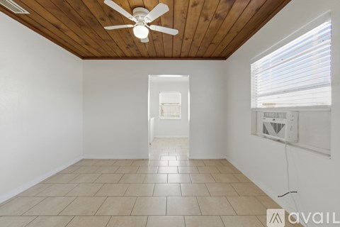 A room with a ceiling fan and tiled flooring.