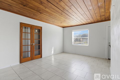 A room with a wooden ceiling and a glass door.