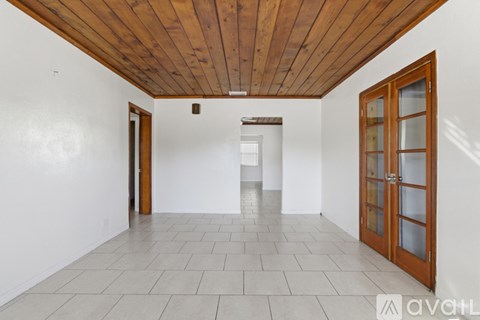 A room with a wooden ceiling and tiled floor.