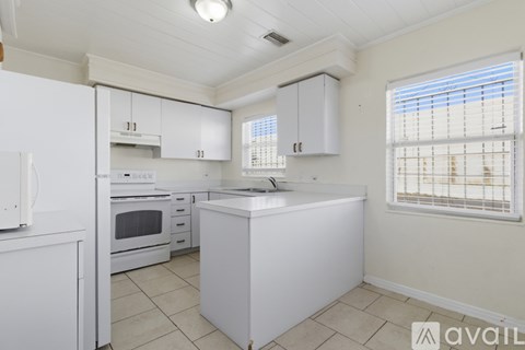 A kitchen with white appliances and cabinets.