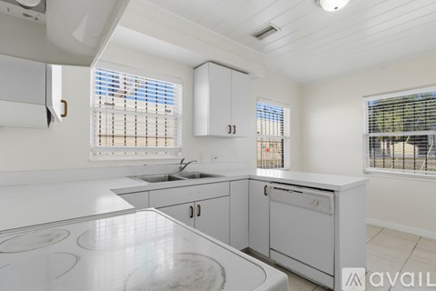 A kitchen with white appliances and cabinets.