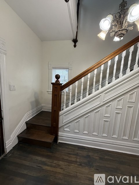 A staircase with a wooden handrail and white balusters.