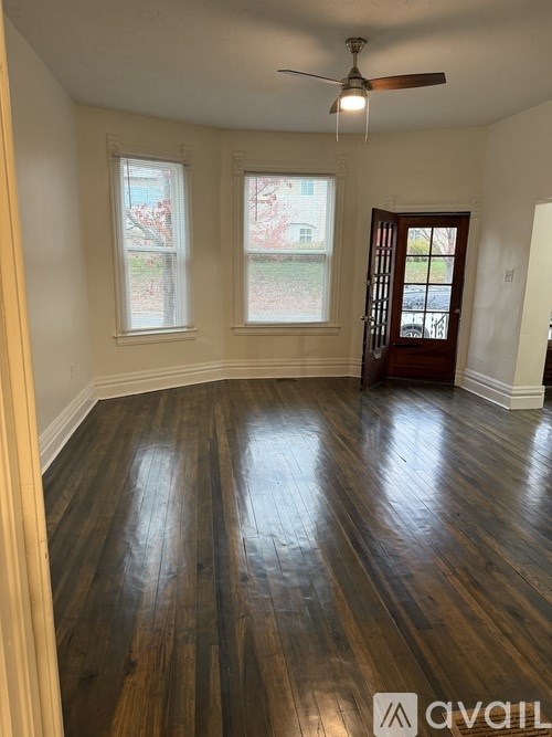 A room with wooden floors and a ceiling fan.