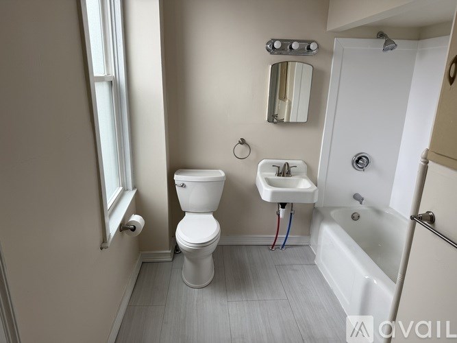 A bathroom with a toilet, sink, and tub.