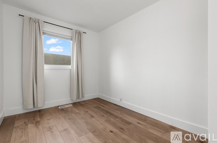 A room with a window and curtains.