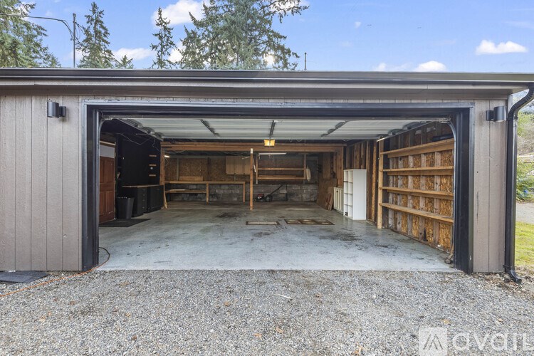 A garage with a door open and shelves inside.