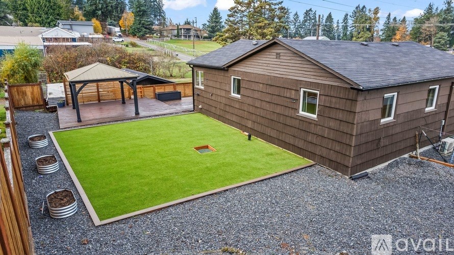A house with a brown siding and a gravel driveway.