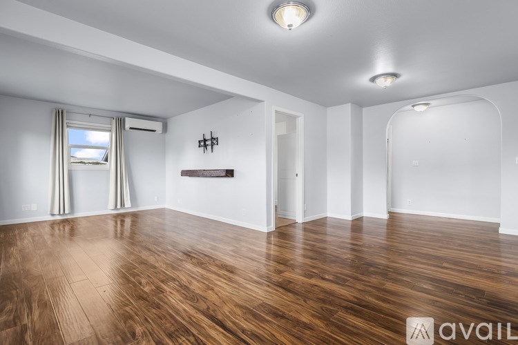 A room with wooden flooring and white walls.