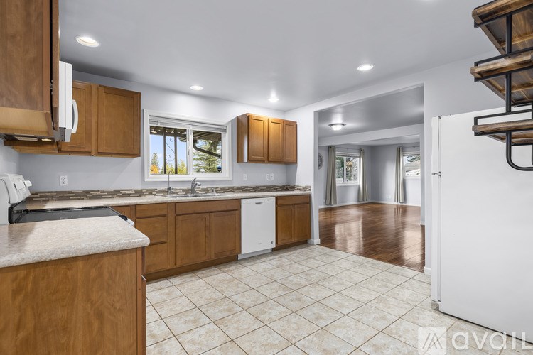 A kitchen with wooden cabinets and a marble countertop.