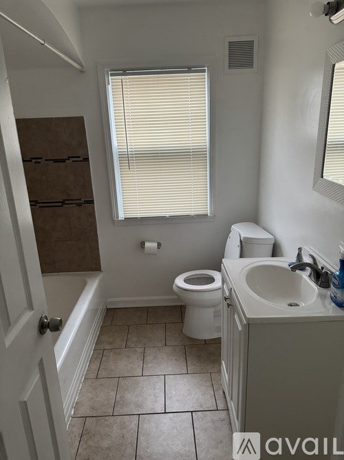 A bathroom with a toilet, sink, and window.