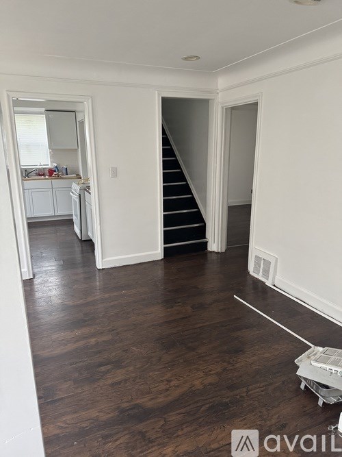 A room with a staircase and wooden flooring.