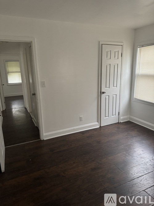 A room with a white door and a window with blinds.