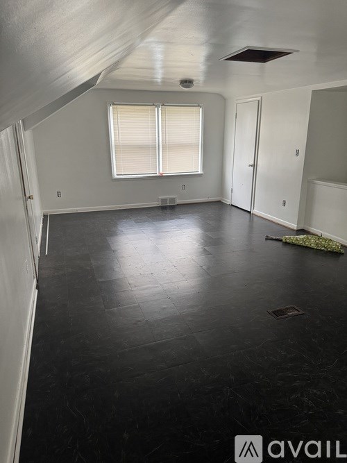 A room with a window and a door is available for rent.