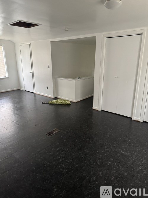 A room with a white bathtub and black flooring.