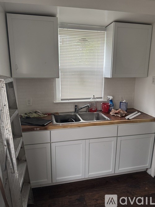 A kitchen with white cabinets and a wooden countertop.
