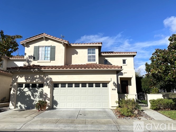 A house with a white garage door and a brown roof.