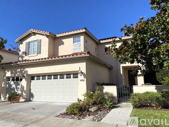A house with a white garage door and a brown roof.