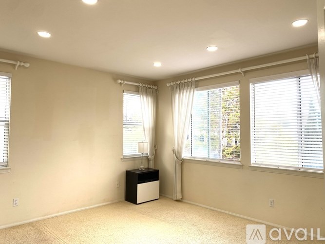 A room with a large window and a white cabinet.