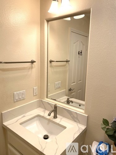 A white bathroom sink with a mirror above it.