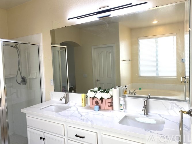 A white bathroom with two sinks and a mirror.