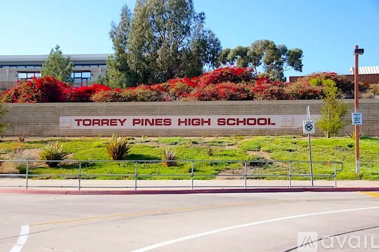 A sign for Torrey Pines High School is displayed in front of a building.