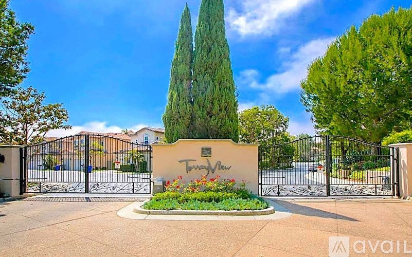 A gated entrance to a property with a sign that says "Tuscany Estates".