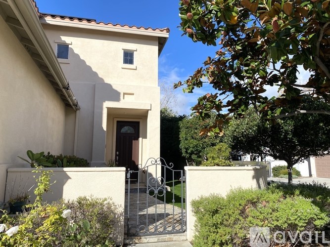 A house with a brown door and a gate in front.