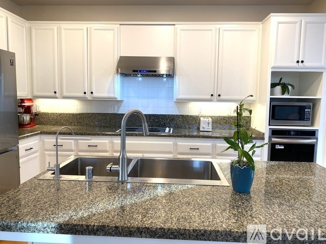 A kitchen with granite countertops and white cabinets.