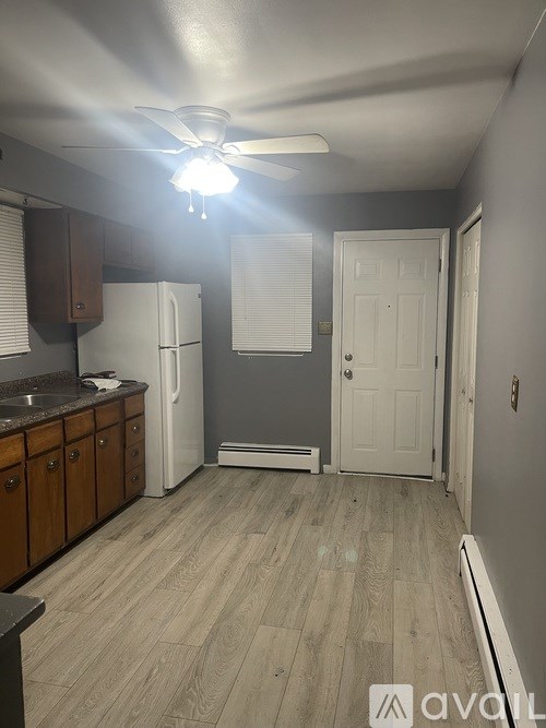 A kitchen with a white refrigerator and wooden cabinets.