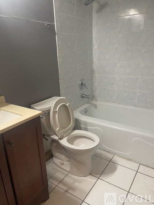 A white toilet with the seat up in a bathroom.