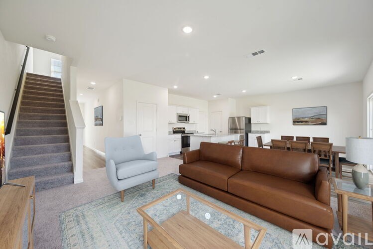 A living room with a brown leather couch and a wooden coffee table.