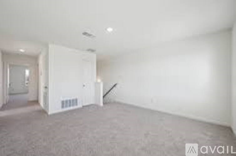 A large empty room with a doorway leading to another room.