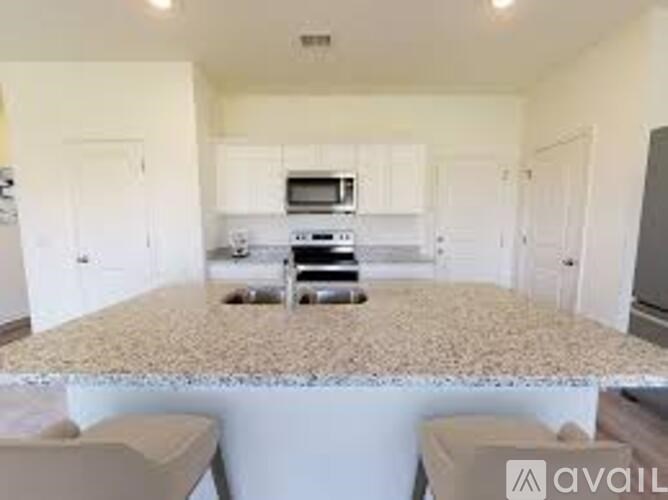 A kitchen with white cabinets and a granite countertop.