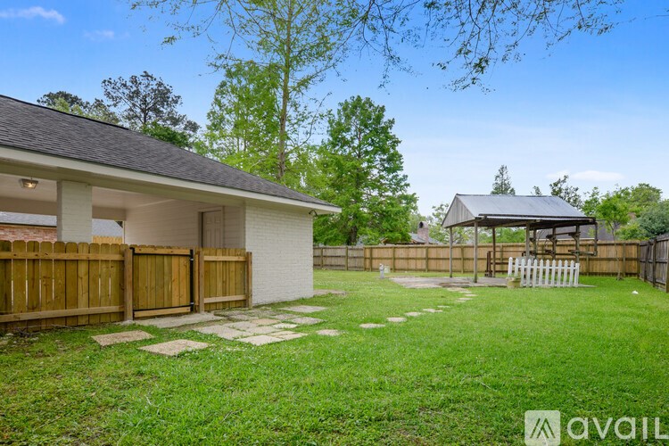 A house with a white fence and a gazebo in the backyard.